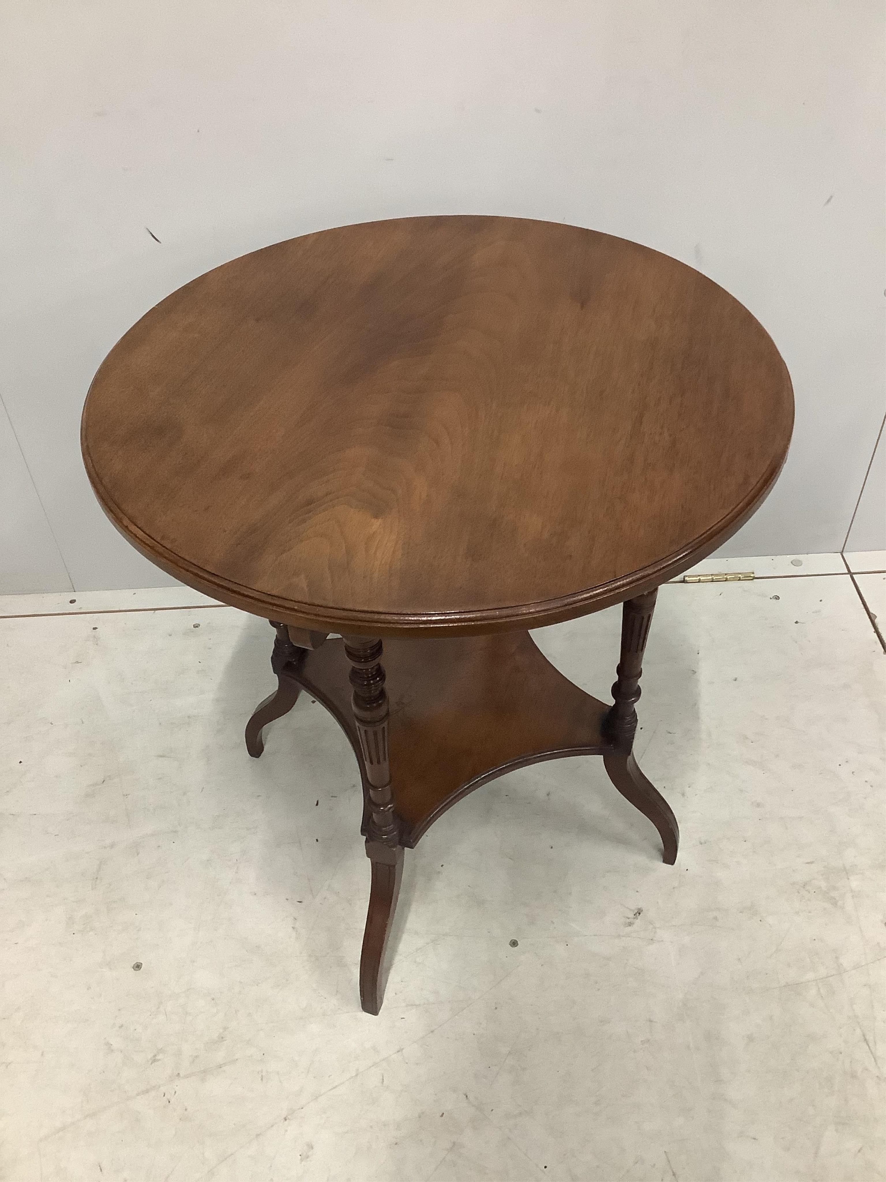 A late Victorian circular walnut two tier occasional table, stamped Gillow &Co ,1555, diameter 60cm, height 65cm. Condition - fair to good